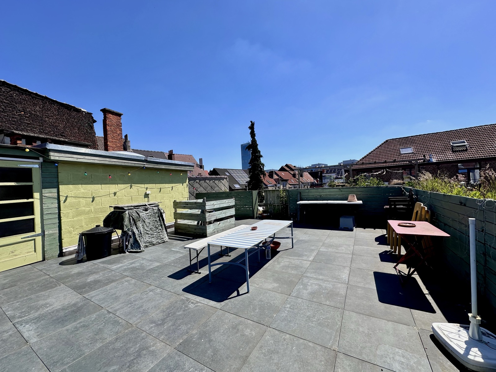 The roof terrace in full sun, looking out over Anderlecht rooftops towards the tower at Midi/Zuid.